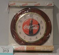 Photo of Coca-Cola Decorator Clock in original box, unopened, showing clock face with logo and bottle graphic.