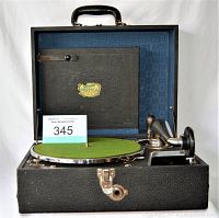 Open vintage Silvertone Portola portable phonograph showing green felt turntable, chrome tonearm components, and interior lid with black panel.