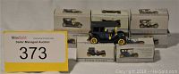Lot of 8 miniature vintage cars, some boxed and some displayed, showing original packaging and various models