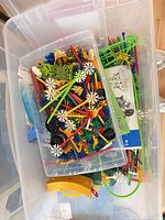 Top view of tote showing mixed K'NEX pieces, wheels, rods and instruction booklets
