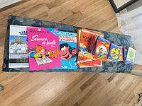 All items laid out on bench showing mixture of large albums and small pocket comics