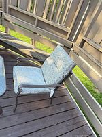 Metal armchair with patterned cushions on wooden deck