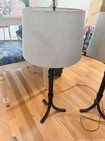 Left table lamp showing bronze base and gray drum shade