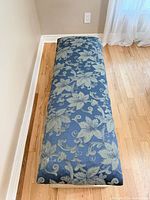 Top view of upholstered seat showing blue floral fabric and wear