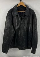 Front view of black leather bomber jacket on hanger