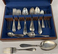 Open wooden case with full flatware set displayed