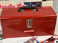 Front view of red Craftsman toolbox with latch and handle, part of original box visible