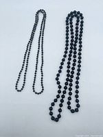 Both necklaces laid flat showing bead size difference