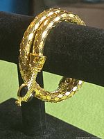 Bracelet coiled on display stand showing scale texture