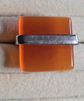 Front view of ring showing orange stone and band