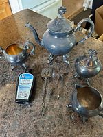 Full view of silver-plated tea set with utensils and polish