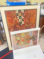 Front view showing both prints, framed abstract behind and rolled floral print in front
