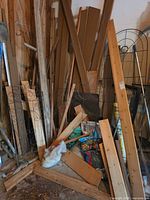 Overall pile: trellis, wood boards, wire cages, drain pipe