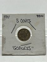 Front of cardboard holder showing reverse side of coin and handwritten notes
