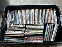 Bin containing approximately 62 DVD cases, spine titles visible