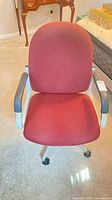 Front view of burgundy fabric swivel desk chair with arms and casters