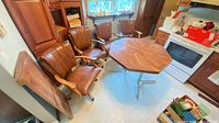 Dining table with leaf installed and four rolling chairs around it