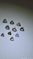 Group of 10 trillion-cut multicolored Tanzanite gemstones on white background