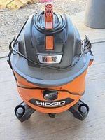 Front view showing RIDGID logo, NXT badge, power cord wrapped on top