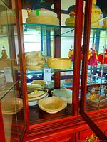cabinet showing assorted dinnerware including lidded dishes, cups, plates and bowls
