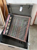 Mixer sitting inside open road case, showing overall condition and foam interior