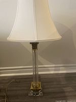 Full lamp front view showing glass neck, brass base, shade