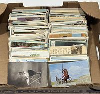 Open cardboard box filled with rows of postcards.