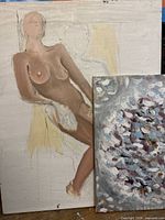 Both paintings leaning together showing size difference and surfaces