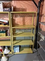 Front view of beige metal shelving unit with five shelves