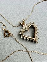 Close-up of heart pendant with stones and attached chain