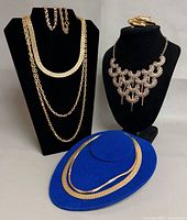 Group shot of all five necklaces and three bracelets on displays