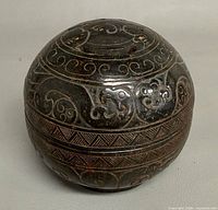 Closed carved stone cricket cage showing side carvings