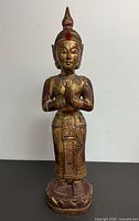 Front view of carved gilt wood Buddha on pedestal