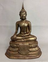 Front view of brass seated Buddha on lotus base