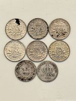 Obverse side of eight coins showing designs and wear