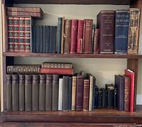 Two shelves of assorted antique/vintage hardcover books showing sets and individual volumes
