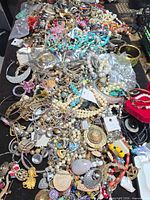 Top view of mixed jewellery spread: rings, necklaces, bracelets, beads