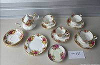 Full set laid out showing teapot, cups, saucers, side plate