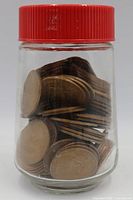 Jar with red lid containing bronze coins