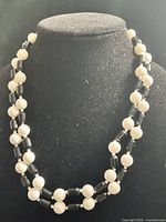 Full view of two-strand black and ivory beaded necklace on bust