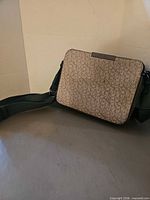 Full view of Calvin Klein monogram crossbody bag front with strap