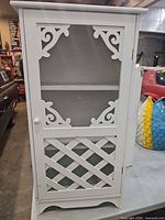 Front view closed showing decorative door panels and knob