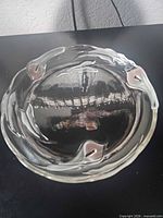 Top view showing round clear glass tray with four pink leaf accents