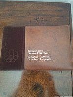 Closed brown album with Olympic emblem and title