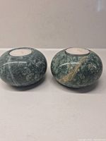 Front view of both green stone tealight holders displaying color and shape