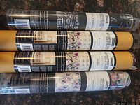 Five sealed rolls of decoupage tissue paper showing assorted label designs