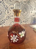 Full view of ruby red glass decanter with stopper inserted