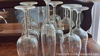 Six assorted clear stemmed glasses upside-down on table