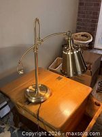 Front view of brass table lamp on wooden surface