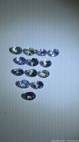 All 13 oval Tanzanites grouped to show colour range and clarity